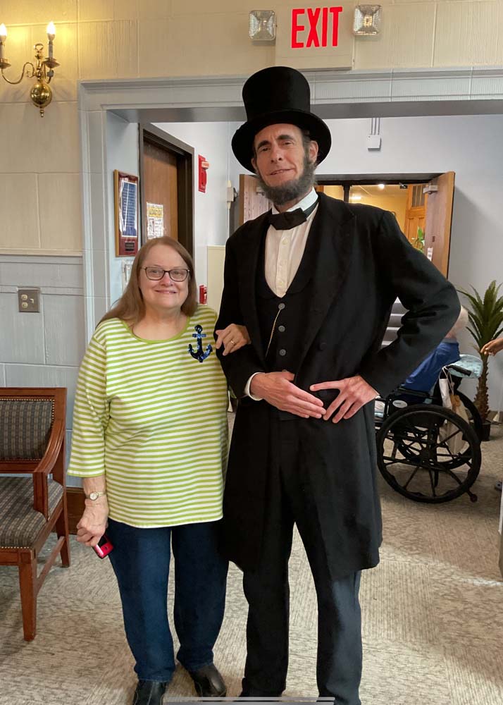 Resident posing with a performer in a common area