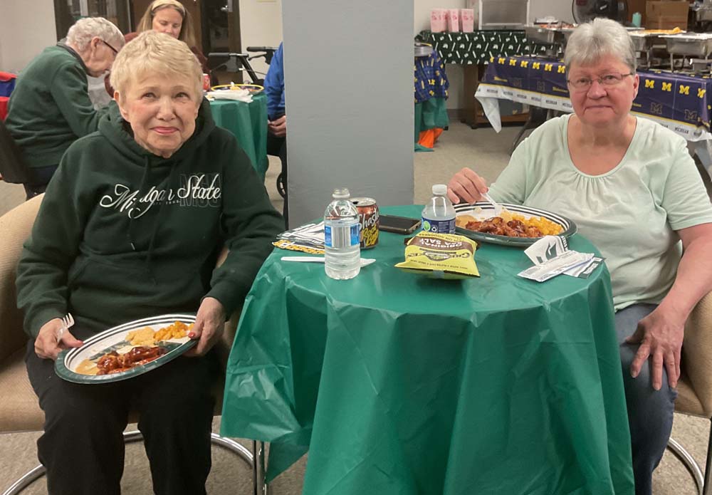 Two residents enjoying meals at a table