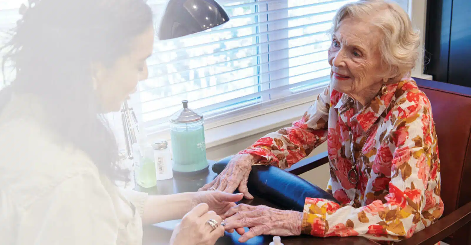 A staff member giving a manicure to a resident