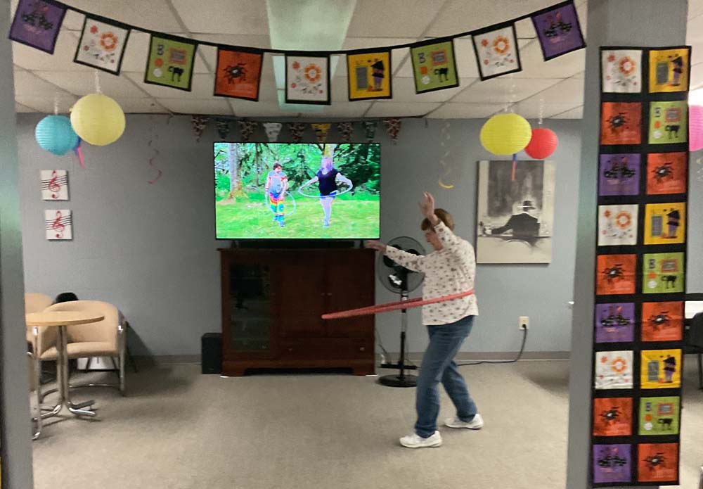 Resident enjoying a hula hoop activity in a common area