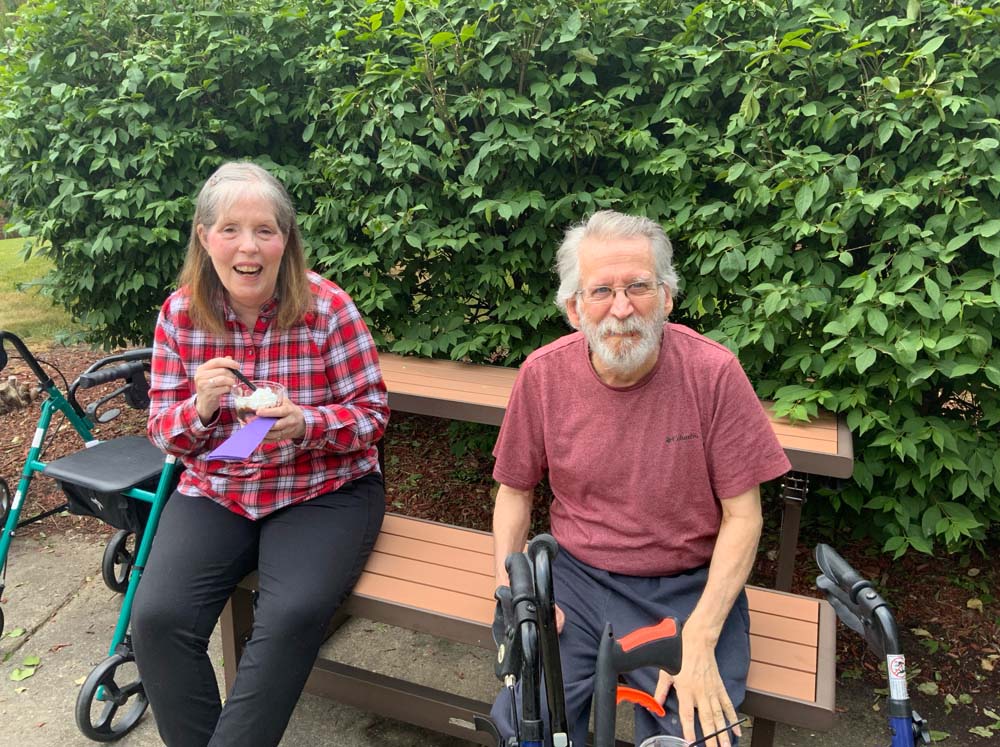 Residents enjoying ice cream outdoors on a bench