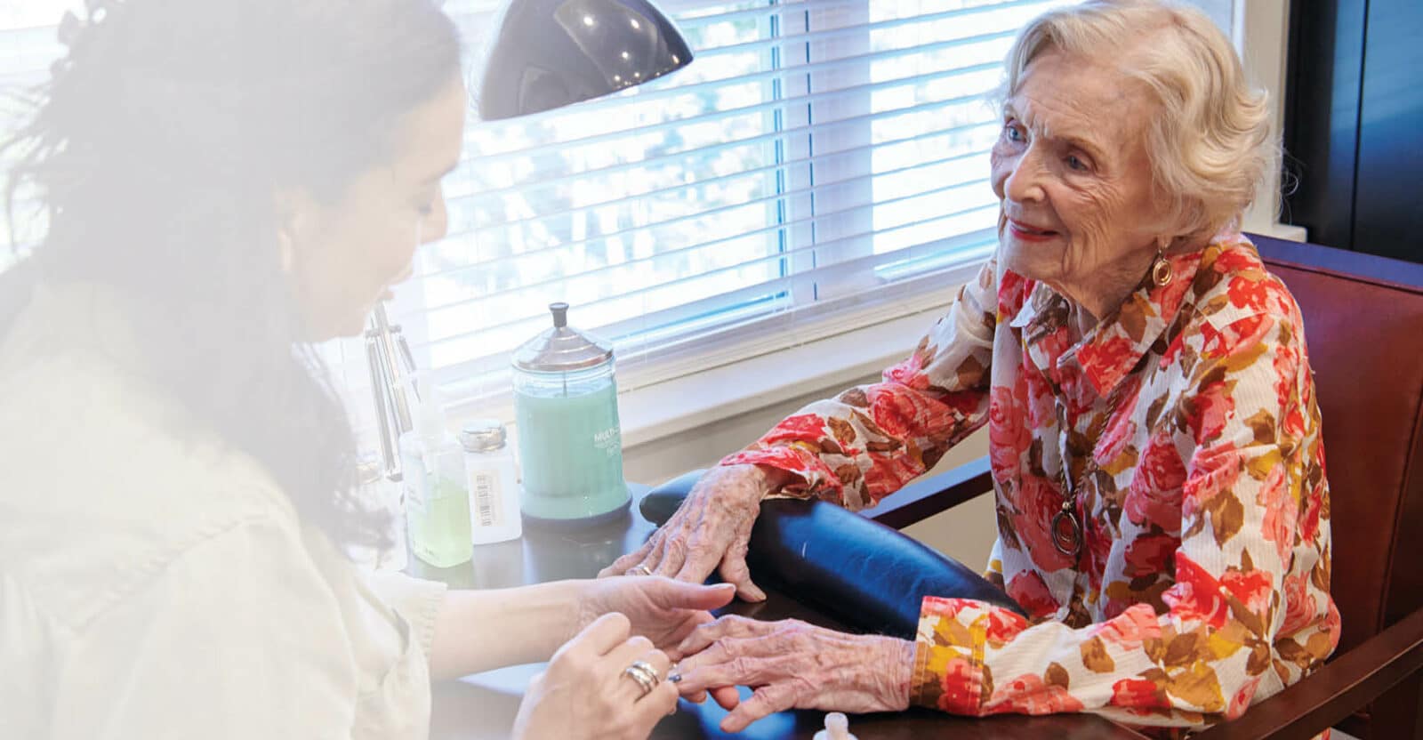 A resident enjoying a manicure in a cozy setting