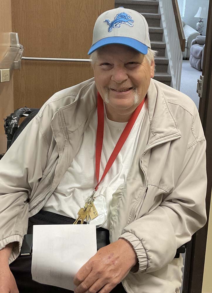 Resident smiling in a wheelchair in a facility