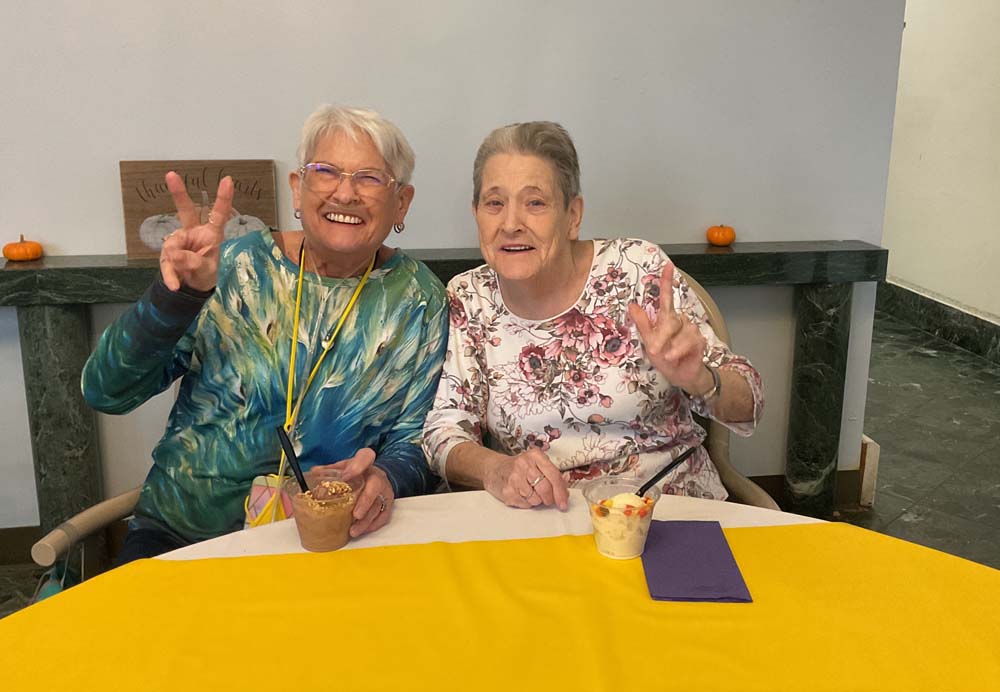 Two female residents enjoying desserts in a common area