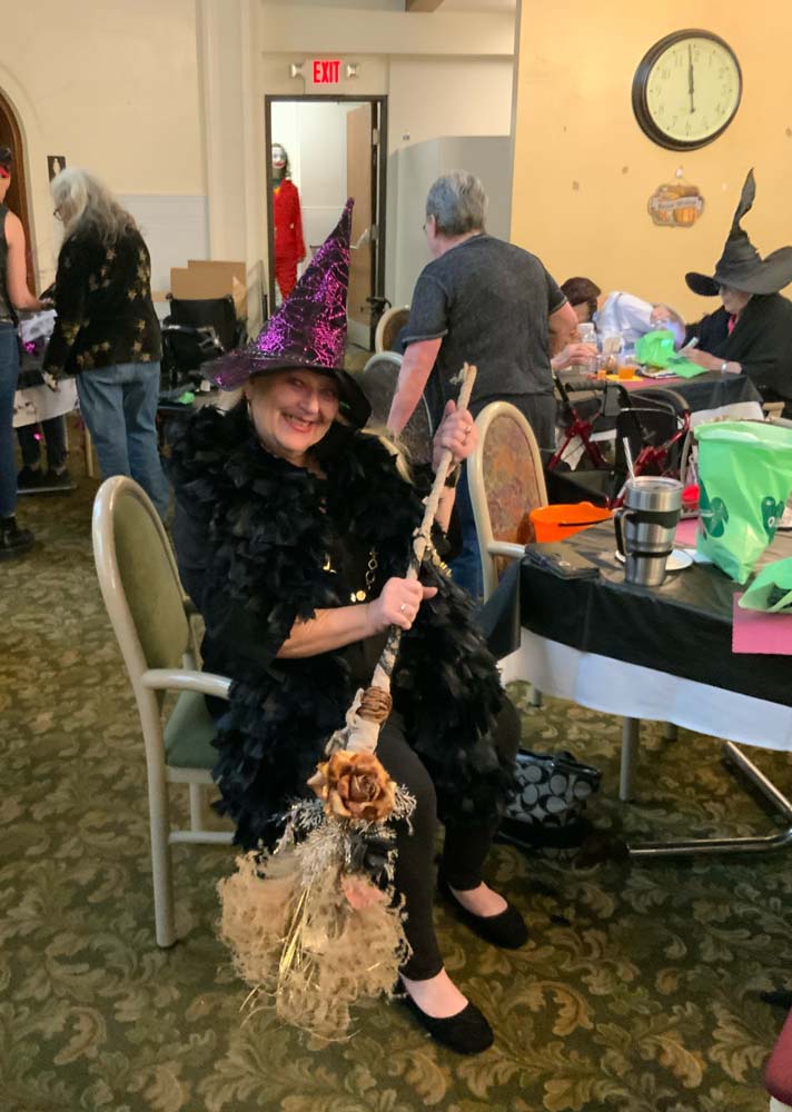 Resident participating in Halloween festivities with a witch costume