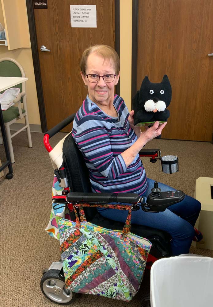 Resident holding a stuffed animal in a facility setting