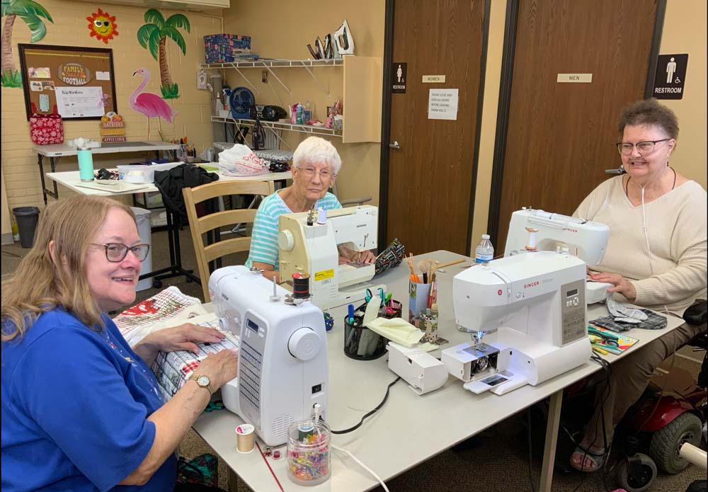 Residents engaged in a sewing activity at a table