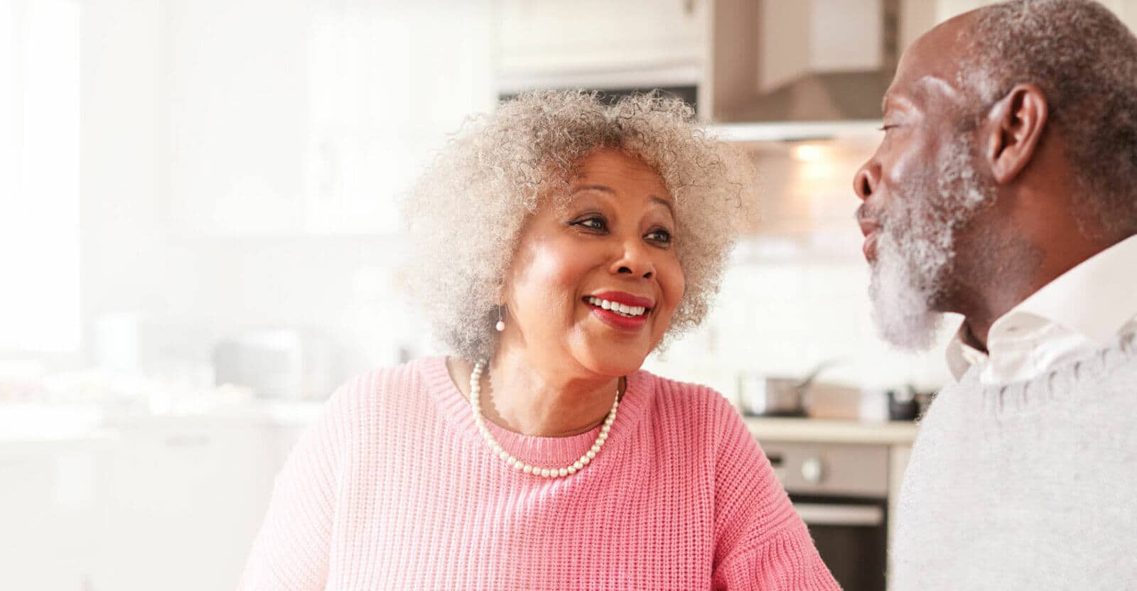 Two smiling residents engaging in conversation indoors