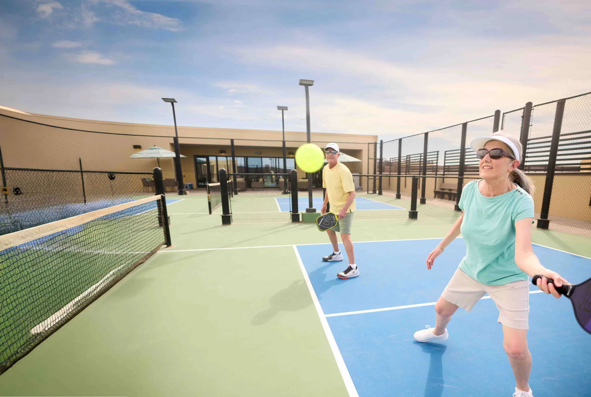 Residents playing pickleball on an outdoor court