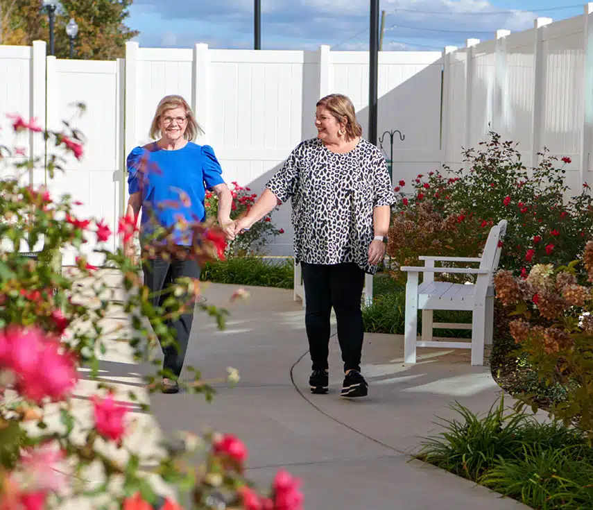 Two women walking in a garden path
