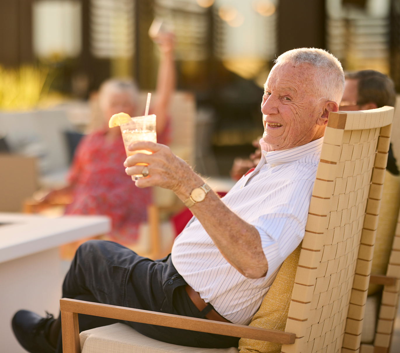 Senior resident enjoying a drink in an outdoor space