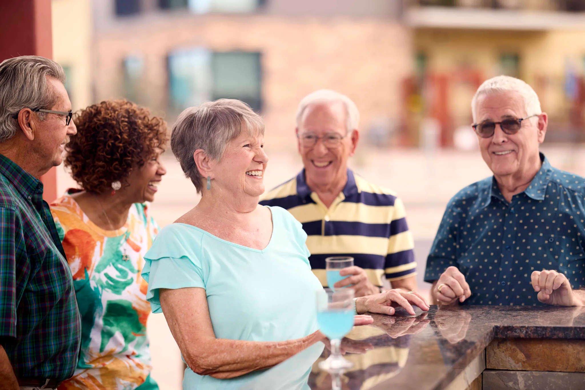 Seniors enjoying drinks and laughter outdoors