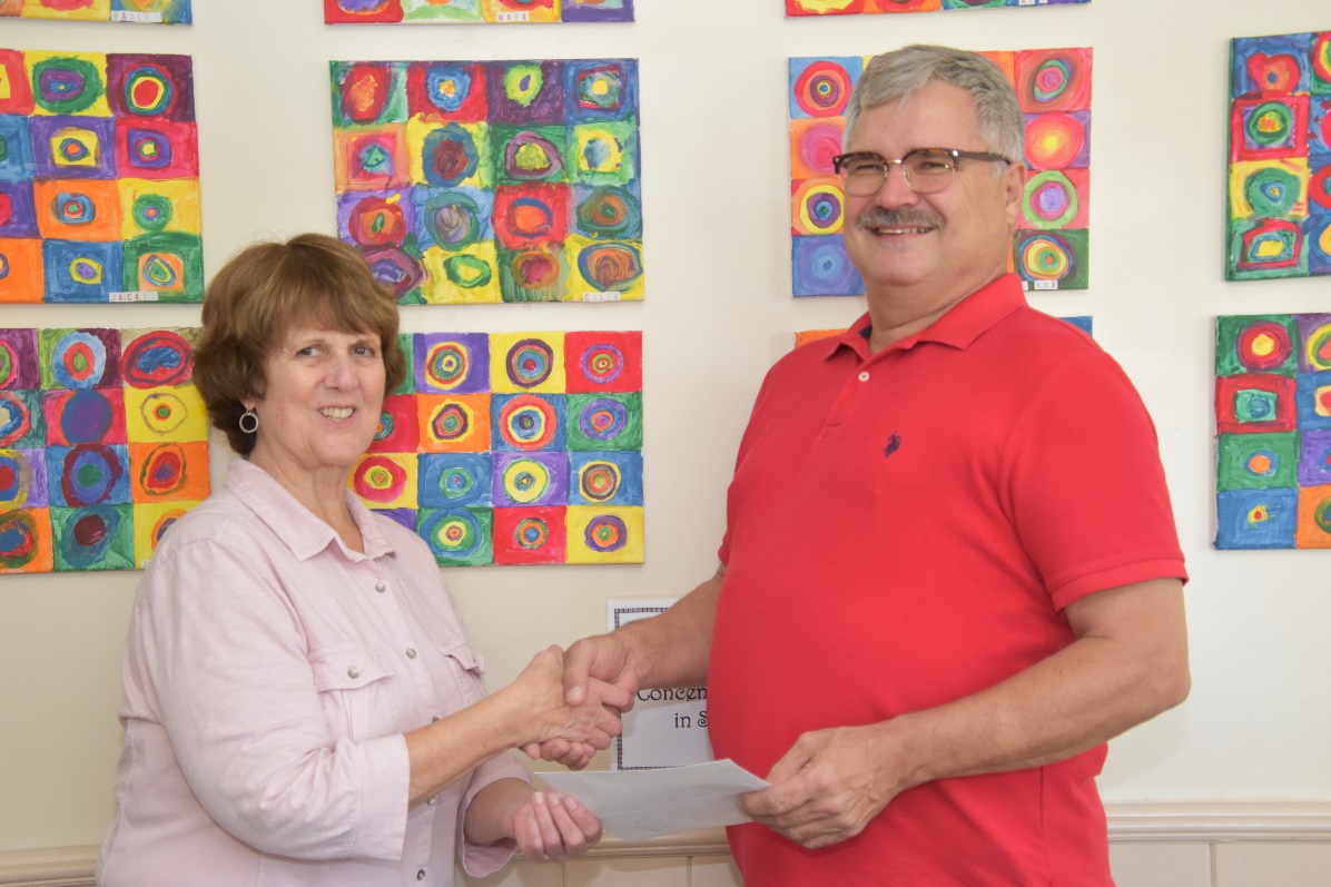 Two residents shaking hands with colorful artwork in background