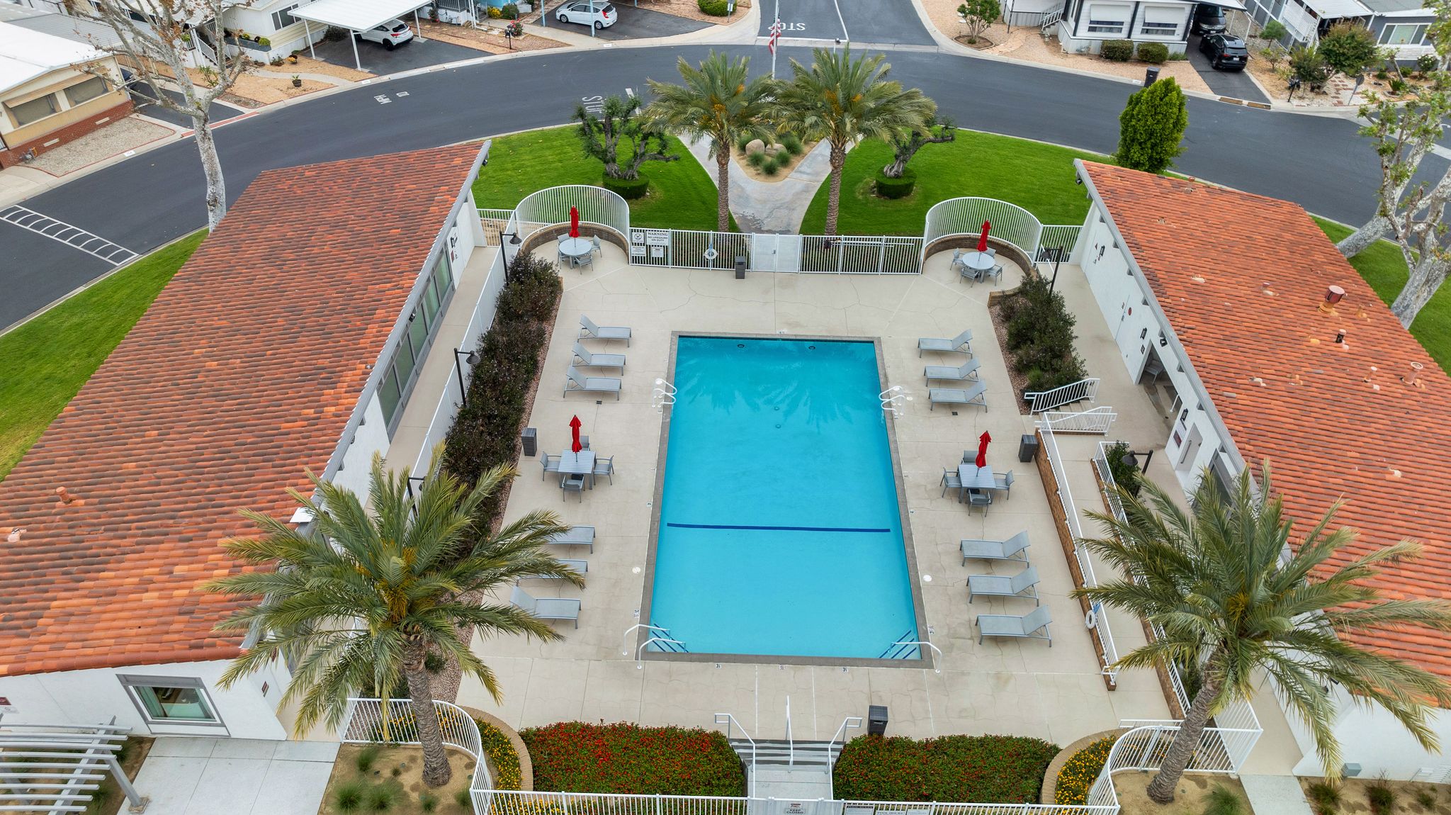 Aerial view of a community pool area with lounge chairs.