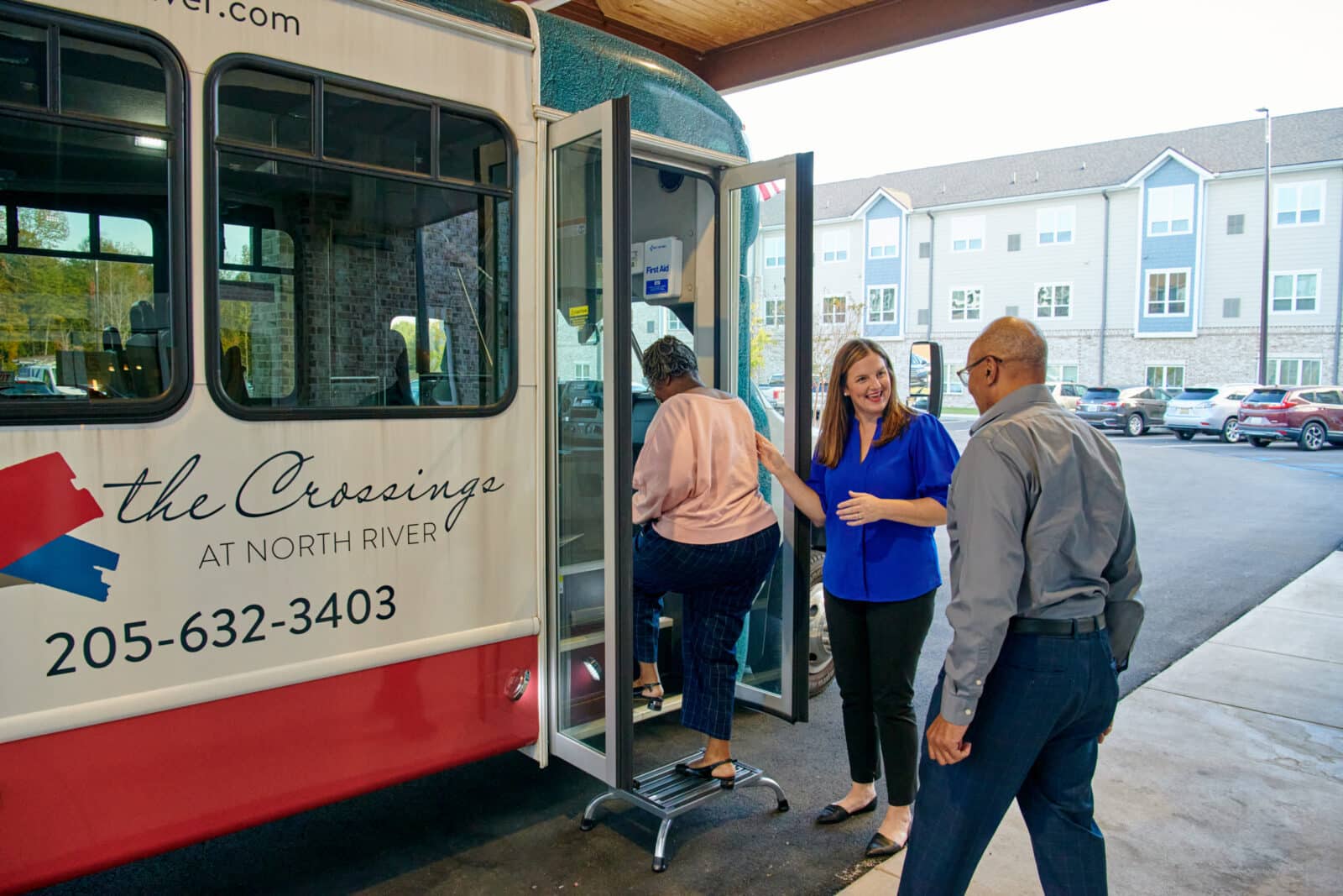 Staff assisting residents boarding a facility shuttle