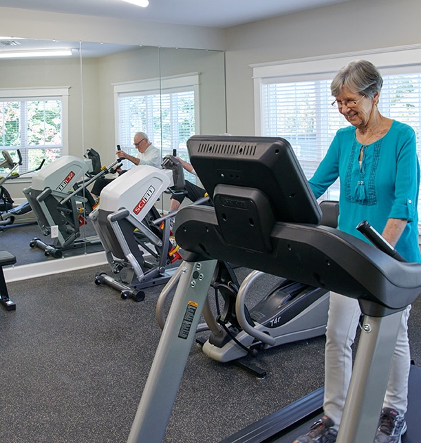 Resident using exercise equipment in a gym
