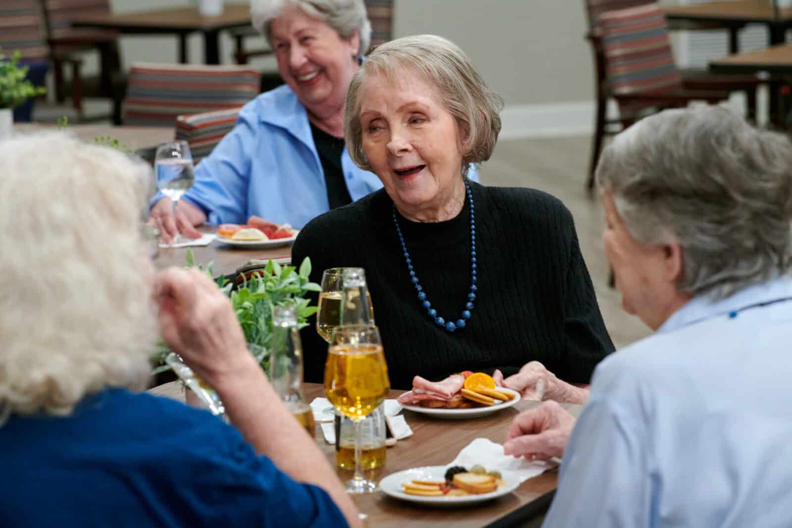 Residents enjoying a meal and conversation in a dining area