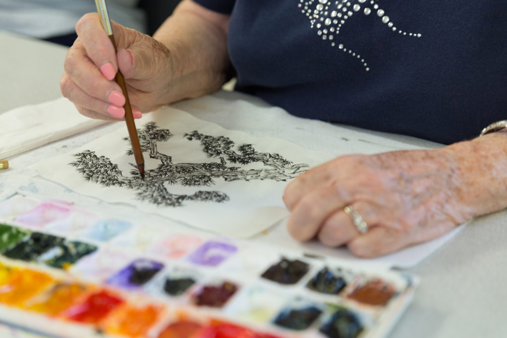Close-up of a resident painting during an art activity