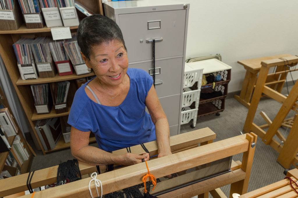 A resident weaving in an activity room