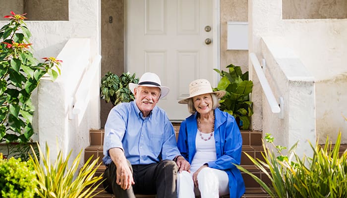 Couple seated on steps in front of a home