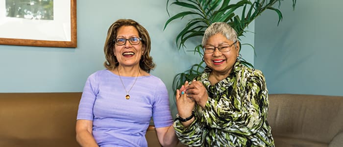 Two women smiling together in a comfortable seating area
