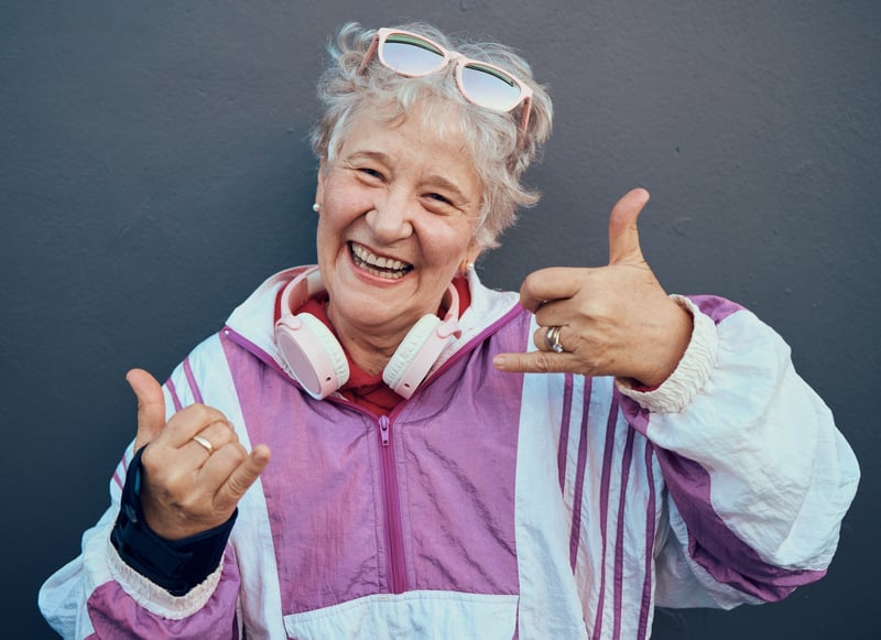 Smiling senior woman with headphones making hand gestures
