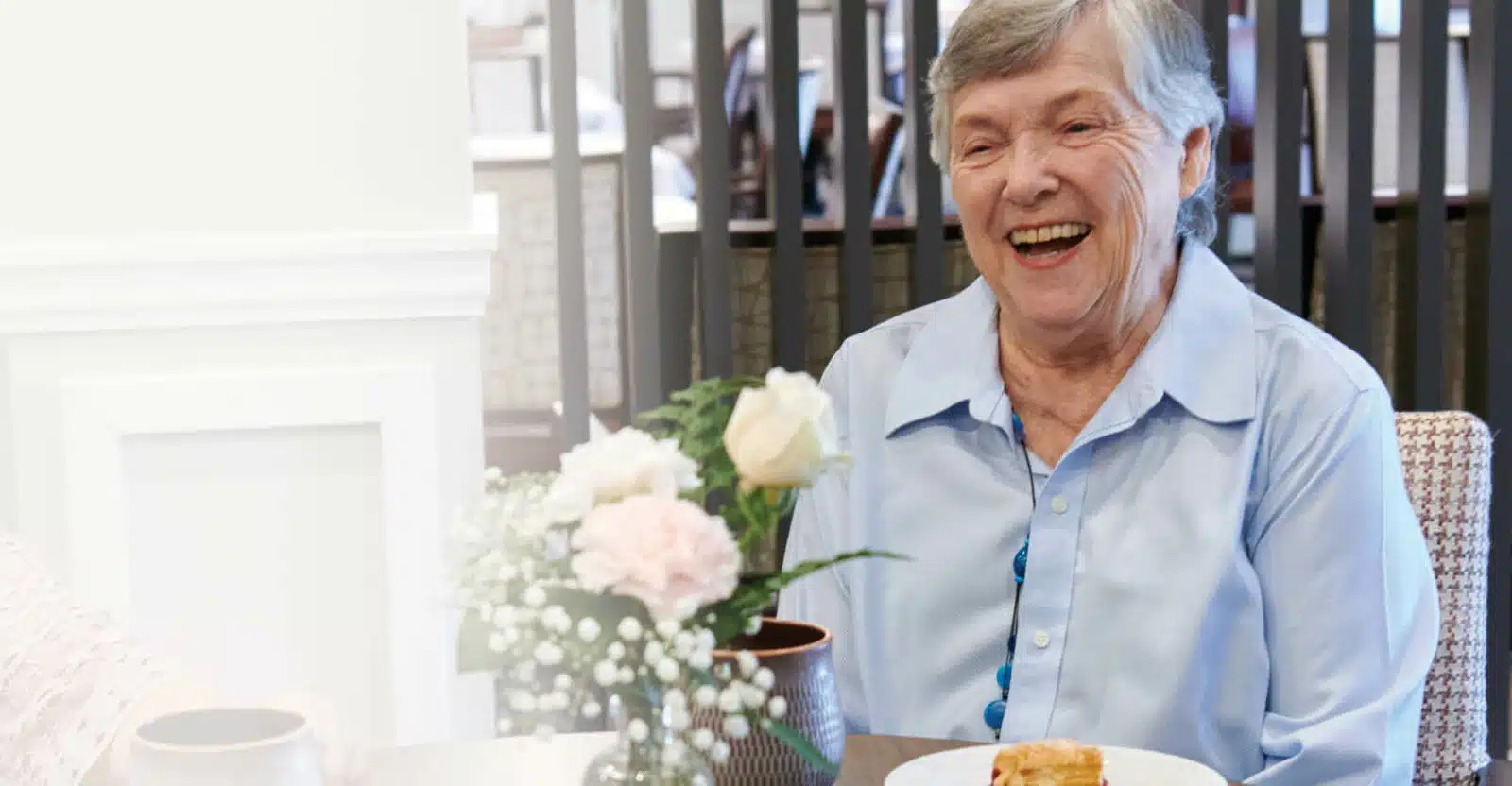 A joyful resident enjoying dessert at a dining table