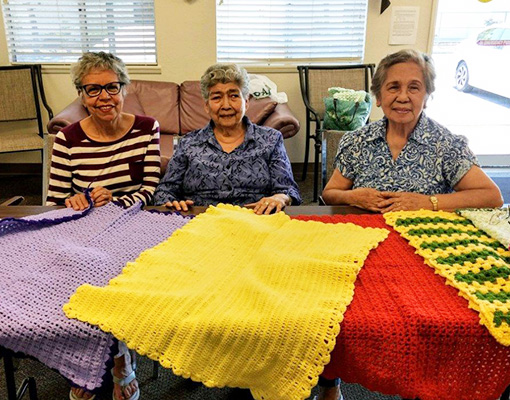 Residents knitting and crocheting in a common area