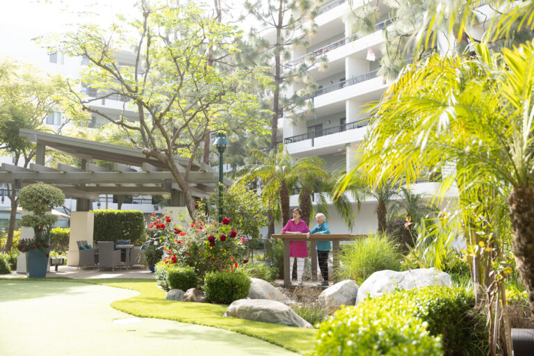 Two women enjoying a garden area with flowers
