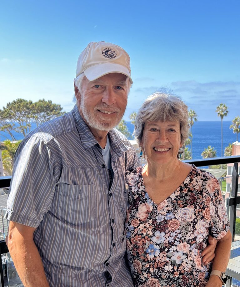 Senior couple posing outdoors with a scenic view