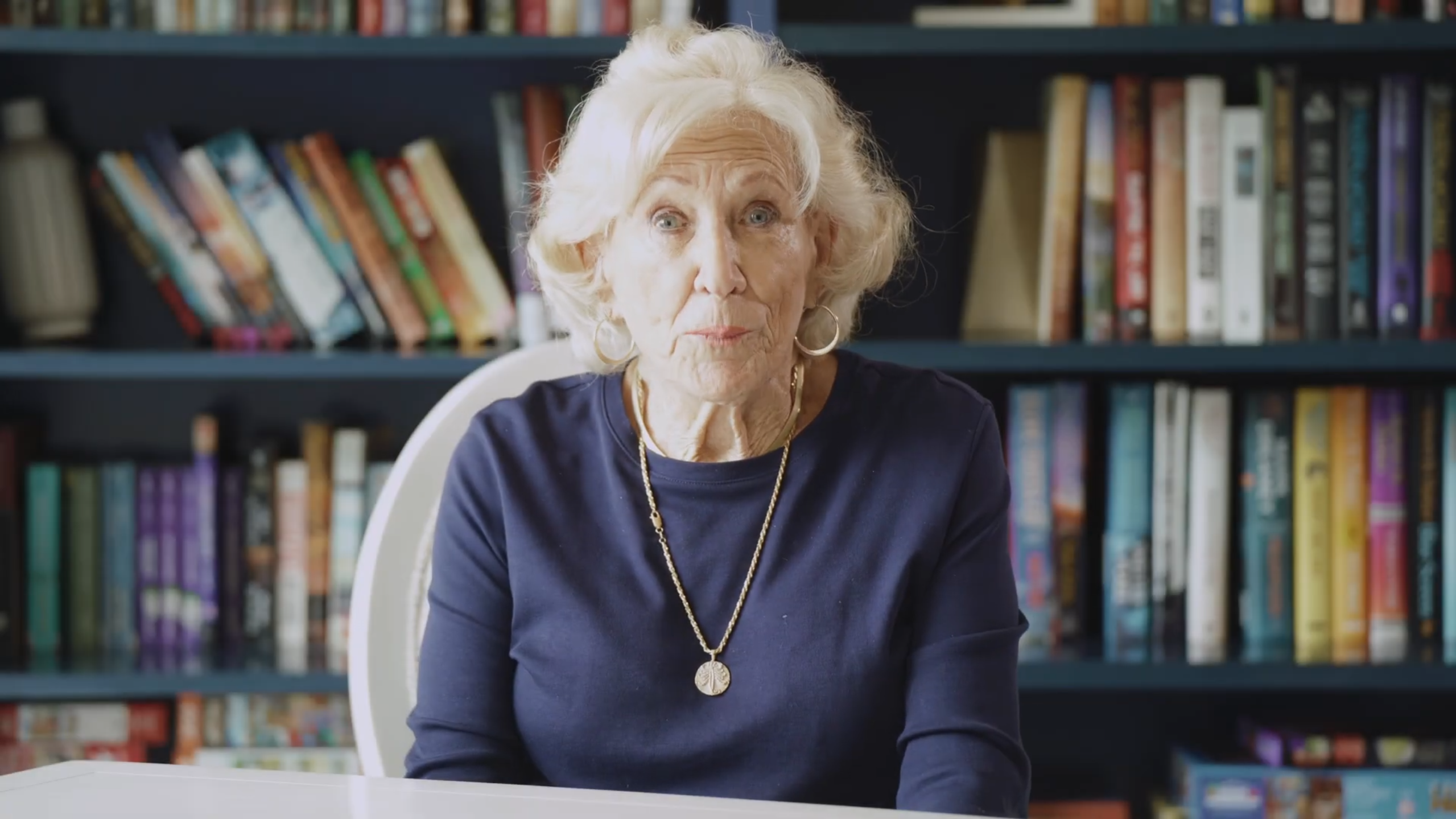 A resident with light hair sitting in a reading area