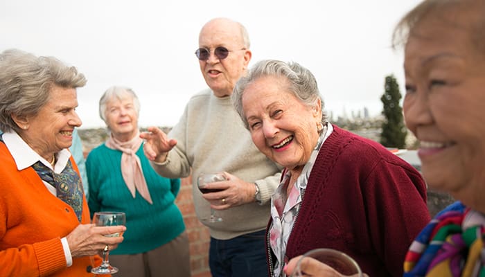 Seniors enjoying drinks and conversation outdoors