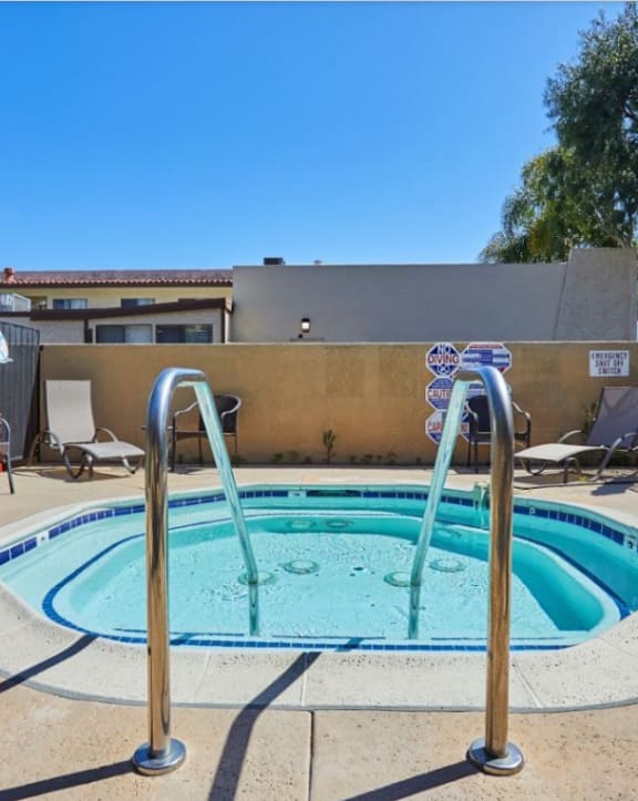 Outdoor spa area with water jets and lounge chairs