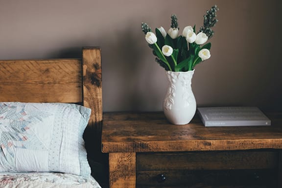 Cozy bedside table with flowers and a book