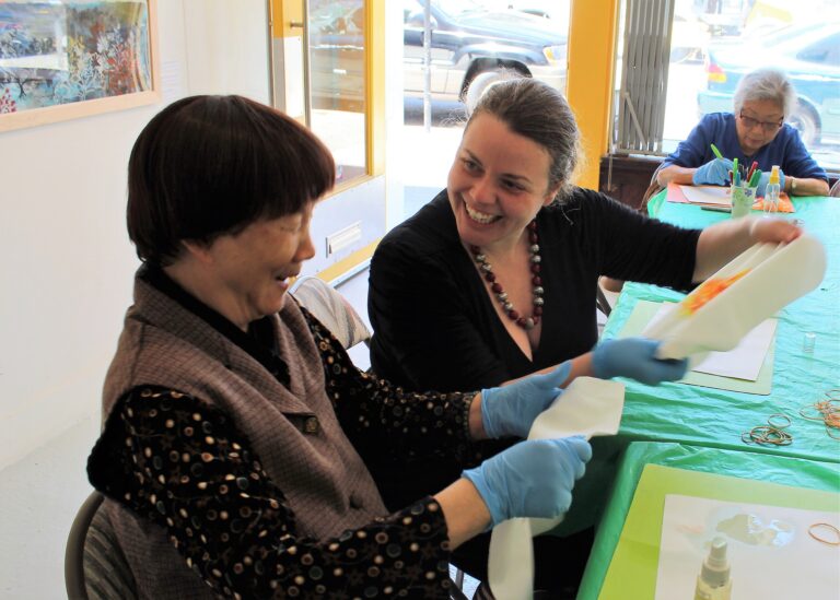 Residents engaged in an art activity with a staff member