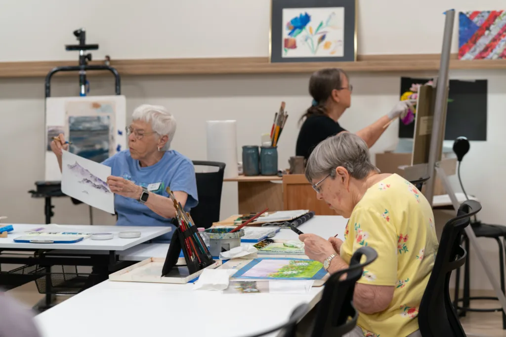 Residents engaged in an art activity in a bright room