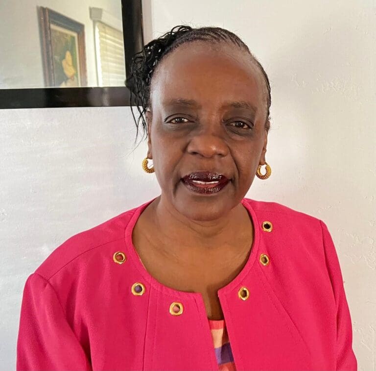 A woman in a pink jacket smiling