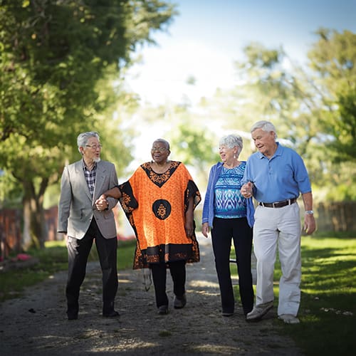 Four residents walking together in a garden