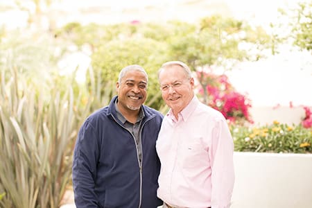 Two smiling residents in a garden setting