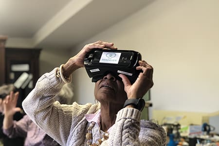 A resident using virtual reality glasses indoors