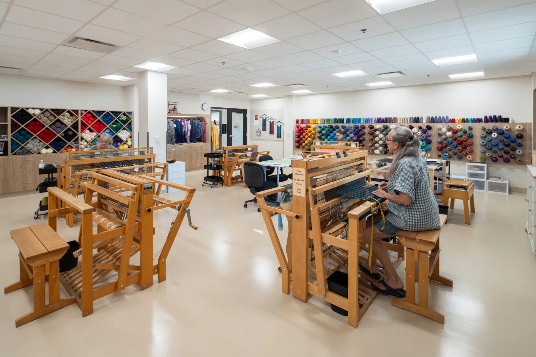 Residents engaged in weaving activities in an activity room