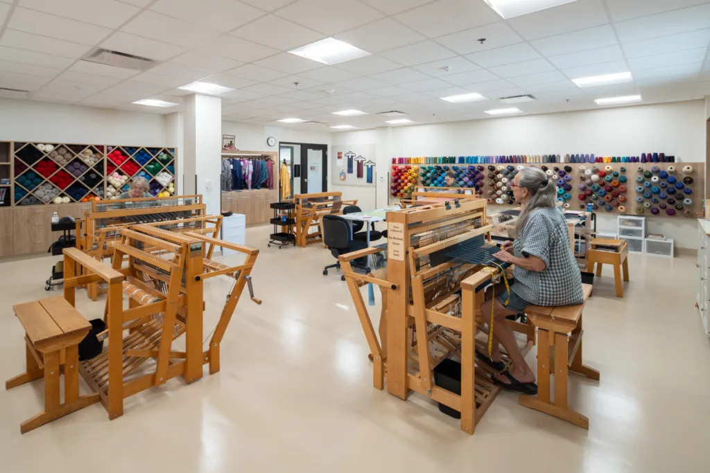 Residents weaving in an arts and crafts room