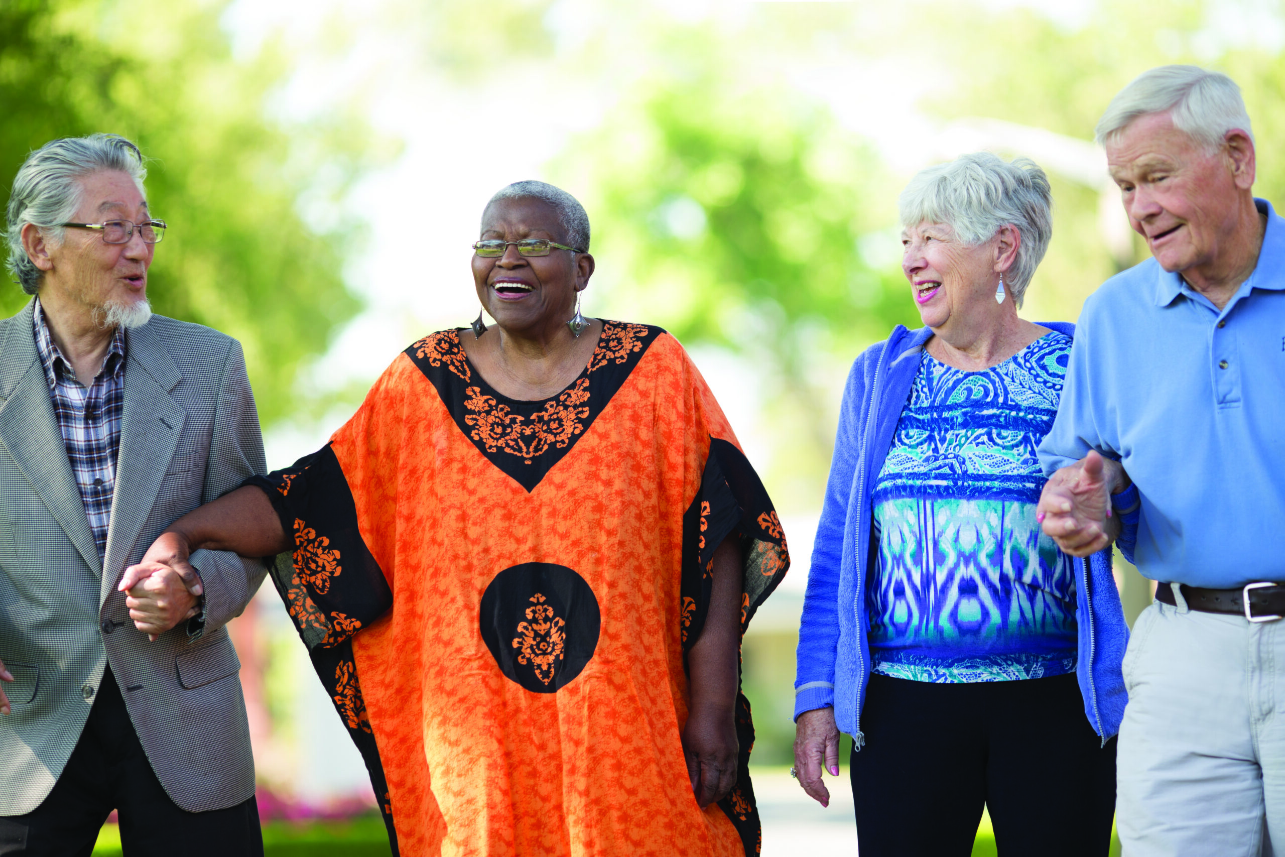 Four residents walking together in a garden