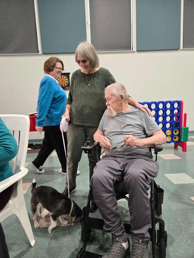 Residents engaging with a pet in a common area