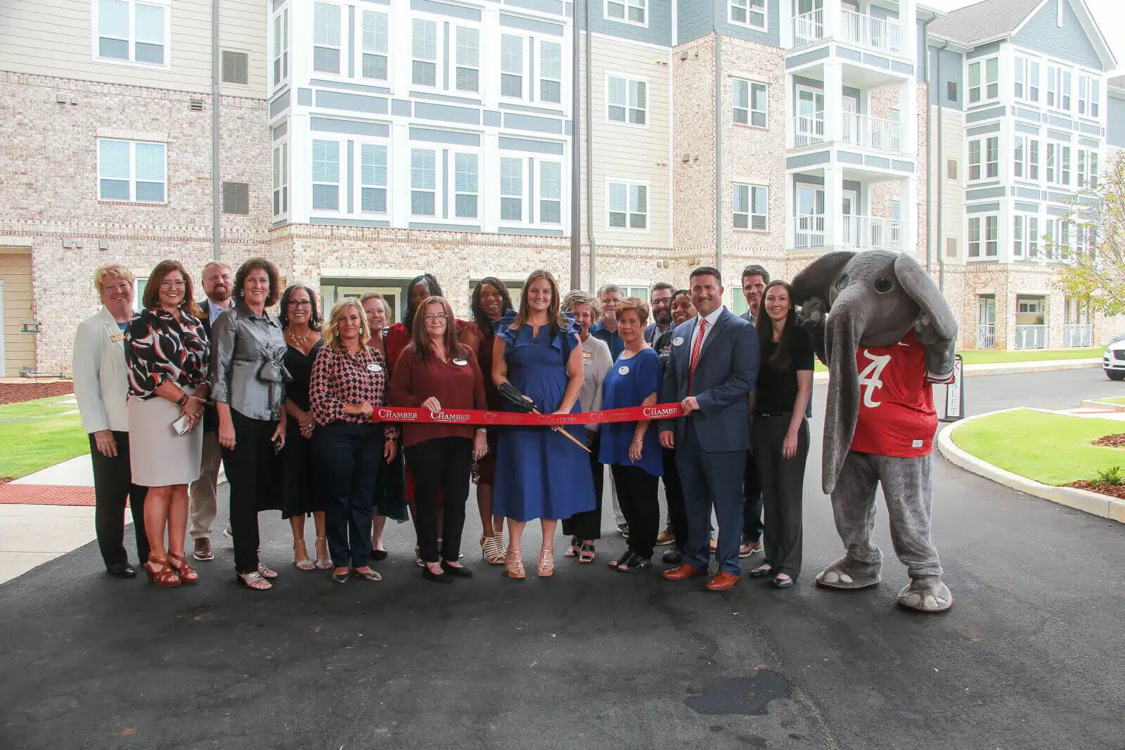Group photo at a ribbon-cutting ceremony outside the facility