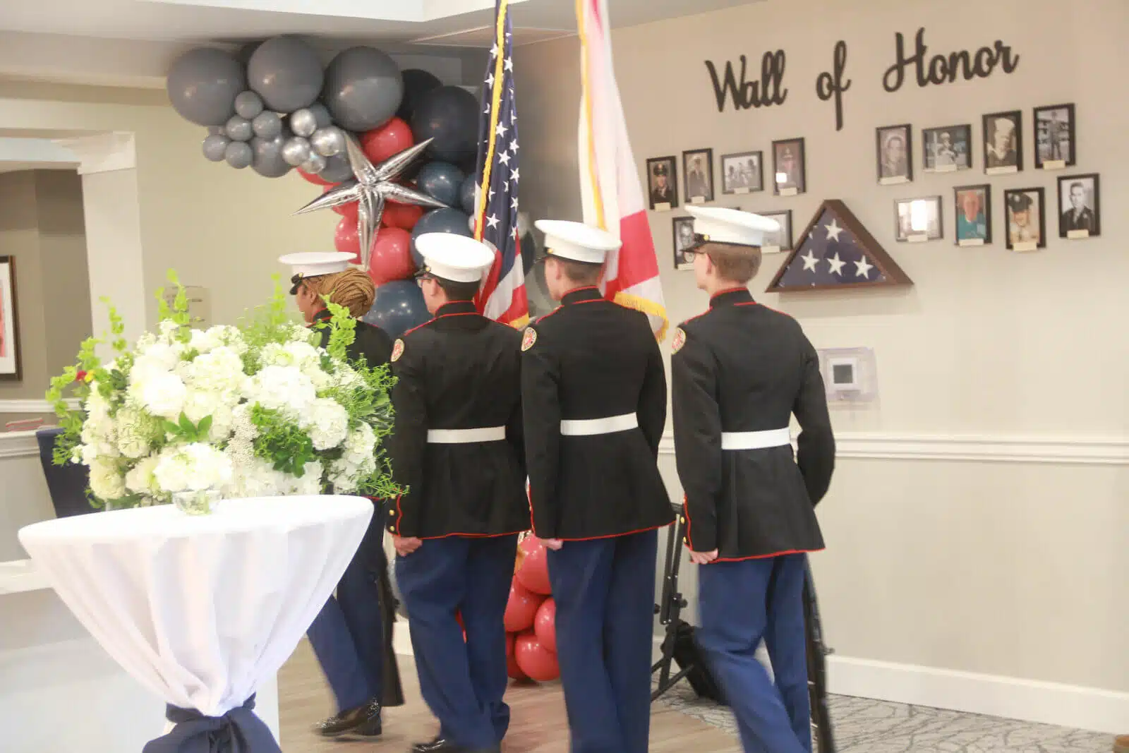 Marines walking past a Wall of Honor in a facility