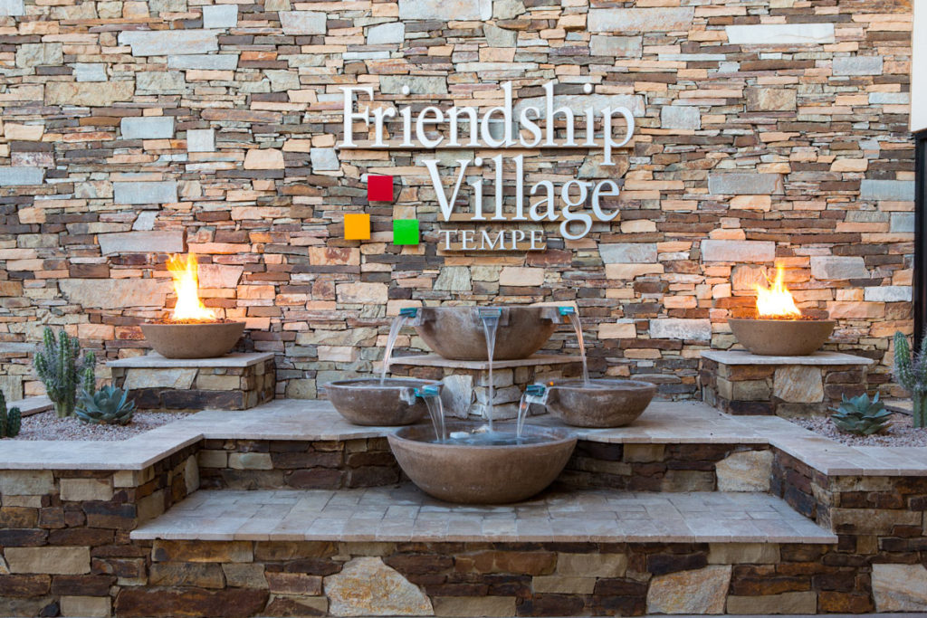 Facility logo on a stone wall with water features