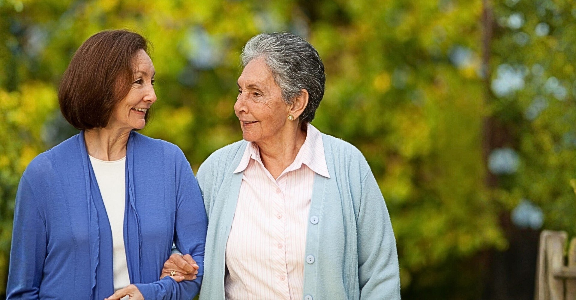 Two residents walking together in a garden