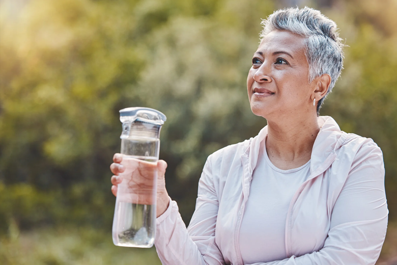 Woman enjoying water in a garden setting