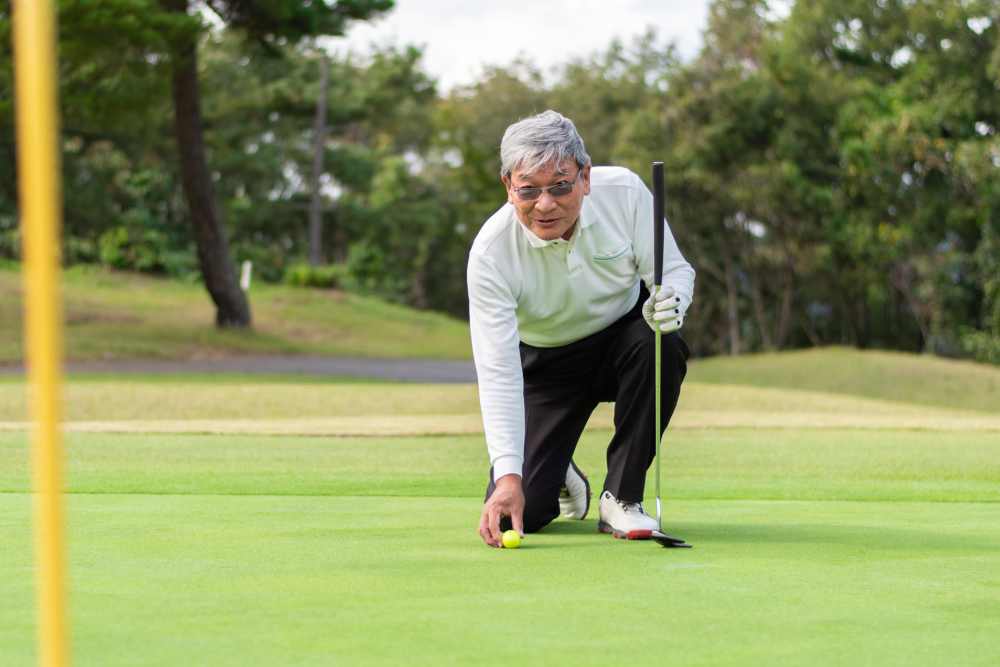 Senior man playing golf on a green